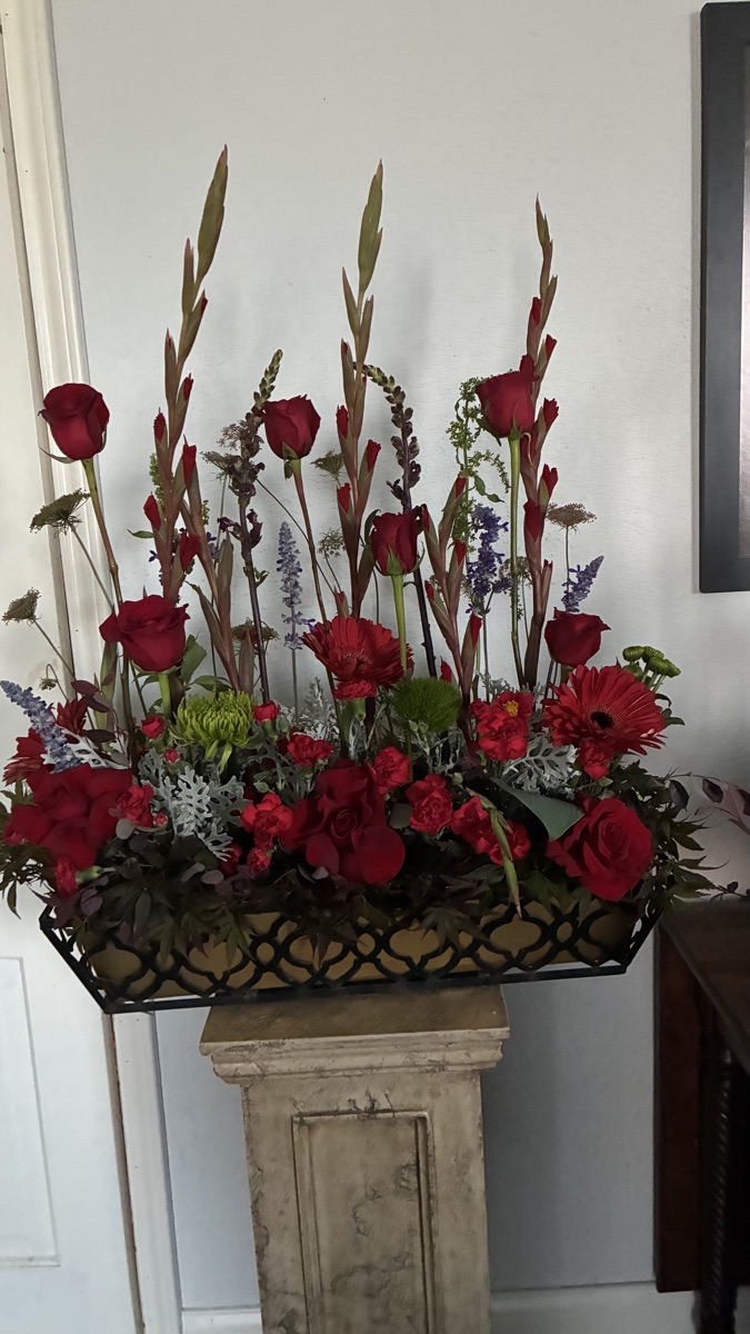 A dramatic row of red roses and gladiolus